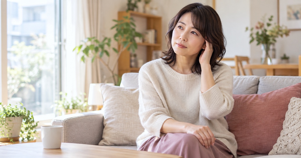 明るい部屋で座って耳に手を添える女性