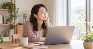 画面から目を離して窓の外を見る女性